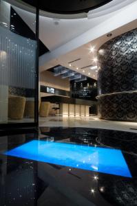 um lobby com uma piscina azul no meio em Hotel Ženeva Lux em Kragujevac