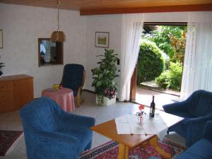 ein Wohnzimmer mit blauen Stühlen und einem Tisch in der Unterkunft Landhaus Schneider in Sasbachwalden