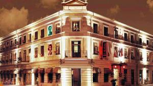 een groot wit gebouw met een klok erop bij Hotel Cherica in Constanţa