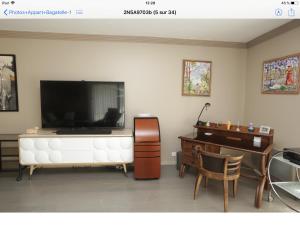 a living room with a flat screen tv and a piano at Deauville rez de jardin/Garden Floor in Deauville
