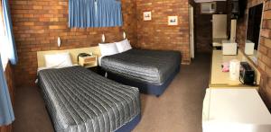 Postel nebo postele na pokoji v ubytování Peter Allen Motor Inn
