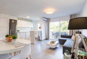 マルベーリャにあるSeaside Marbella Apartmentsのリビングルーム、キッチン(ソファ、テーブル付)