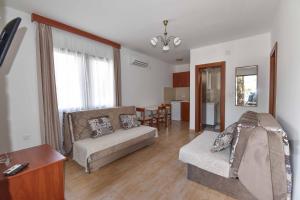een woonkamer met een bank en een tafel bij Studio Apartments 6 Palmi in Budva