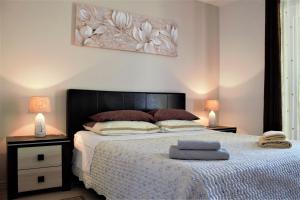 um quarto com uma cama e dois candeeiros e um quadro em Apartments & Room Anita em Rovinj