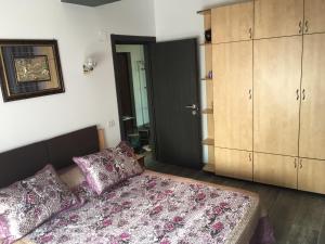 a bedroom with a bed and a cabinet and a door at Ana Apartament in Mamaia Nord