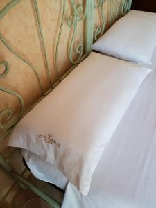 ガリポリにあるVilla Belvedere di Ritaの白い枕付きベッドのクローズアップ