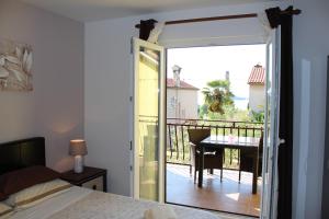 1 dormitorio con puerta que da a un balcón con mesa en Apartments & Room Anita, en Rovinj