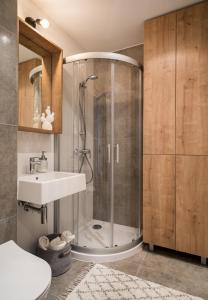een badkamer met een douche en een wastafel bij udanypobyt Smrekova Apartament in Zakopane