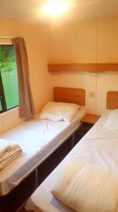 A bed or beds in a room at Camping de la Reuille
