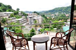 a balcony with a table and two chairs and a view at Highest View in Kandy