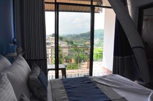 een slaapkamer met een bed en uitzicht op een balkon bij Highest View in Kandy