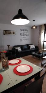 チクラナ・デ・ラ・フロンテーラにあるZambra. Luminoso y coqueto apartamento en Chiclanaのリビングルーム(テーブル、赤と白の皿付)