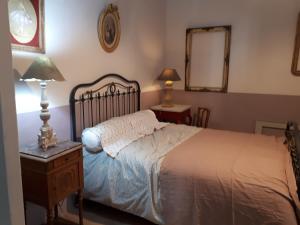 カルパントラにあるL'esperluette fleurie Carpentras centre historiqueのベッドルーム1室(ベッド1台、ランプ付きテーブル2台付)