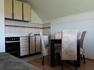 a kitchen with a table and chairs and a sink at Apartments Markoni in Zlatibor