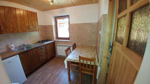 a small kitchen with a table and a sink at Chatka Bukowina in Wetlina