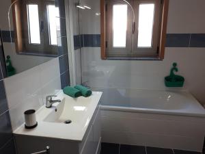 La salle de bains est pourvue d'un lavabo et d'une baignoire. dans l'établissement Apartamento Mirabelle, à Praia de Mira