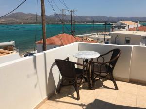 ein Tisch und zwei Stühle auf einem Balkon mit dem Wasser in der Unterkunft Lafotel in Elafonisos