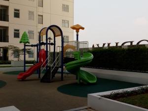 a playground with a green slide in a courtyard at Apartment Kota Ayodhya - Christine in Tangerang