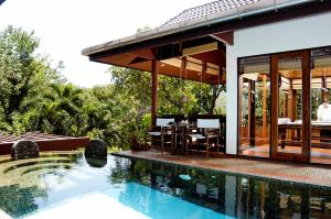 a house with a swimming pool next to a house at Mom Tri's Villa Royale - SHA Plus in Kata Beach