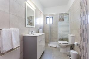 a white bathroom with a toilet and a sink at Carol's Beco Apartments in Lagos +39 photos