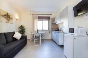 a small living room with a couch and a kitchen at Carol's Beco Apartments in Lagos