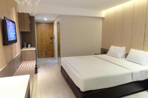 Postel nebo postele na pokoji v ubytování Golden City Rayong Hotel