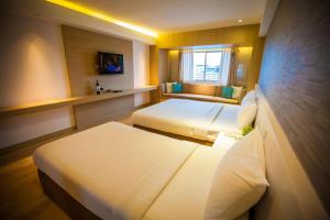 Postel nebo postele na pokoji v ubytování Golden City Rayong Hotel