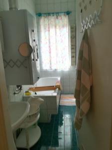 赫維茲的住宿－Violetta apartmanlakás，浴室配有盥洗盆、卫生间和浴缸。