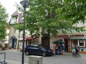 een blauwe auto geparkeerd voor een gebouw bij Violetta apartmanlakás in Hévíz