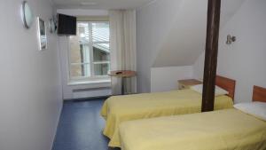 パルヌにあるホッミク ゲストハウスのベッド2台と窓が備わるホテルルームです。