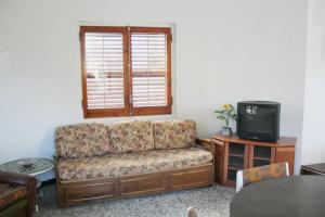 salon z kanapą i telewizorem w obiekcie Crisson w mieście L'Escala