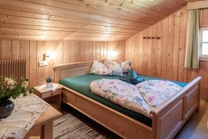 a bedroom with a bed in a log cabin at Oberhabererhof in Santa Maddalena in Casies