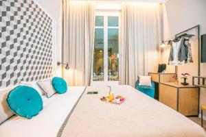 a bedroom with a large bed with blue chairs at Mosaic by Ona in Barcelona