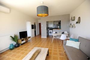 una sala de estar con un sofá y una mesa en T2 Terrasse Vue Mer - Route des Sanguinaires, en Ajaccio
