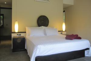 a bedroom with a large white bed with two lights at Beachfront TalingNgam in Taling Ngam Beach