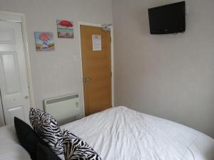 a bedroom with a bed and a television on the wall at The Royal Bridlington in Bridlington