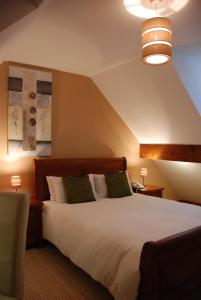 a bedroom with a large white bed with two green pillows at The Port House in Heysham