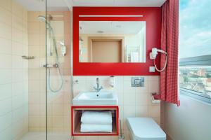 a bathroom with a sink and a shower with a mirror at Hotel Altus Poznań Old Town - Destigo Hotels in Poznań