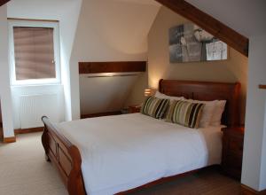 a bedroom with a large white bed and a window at The Port House in Heysham