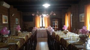 Habitación con mesas largas con globos rosas y velas en Agriturismo Petrosa, en Castrovillari