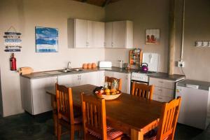 una cucina con tavolo in legno e ciotola di frutta di Seaview Cottage a Coffee Bay