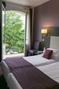 Cette chambre comprend deux lits et une grande fenêtre. dans l'établissement Best Western Hôtel De France, à Chinon