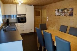 グレヘンにあるChalet Dajanaのキッチン(木製テーブル、青い椅子付)