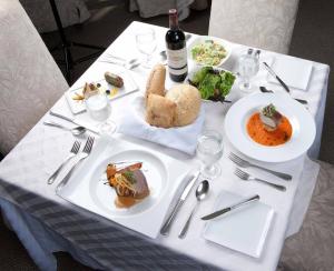 a white table with plates of food and a bottle of wine at Mayaguez Resort & Casino in Mayaguez +22 photos