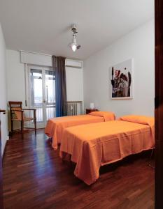 a room with three beds with orange sheets at Buona Luce in Verona +20 photos