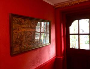 
a red wall with a picture of a red wall on it at B&B Bij de Boomgaard in Tricht
