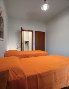 a bedroom with two beds with orange sheets and a mirror at Buona Luce in Verona