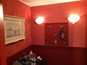 
a room with a red wall and a red wall at B&B Bij de Boomgaard in Tricht
