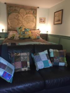 
a couch with pillows and pillows on it at B&B Bij de Boomgaard in Tricht
