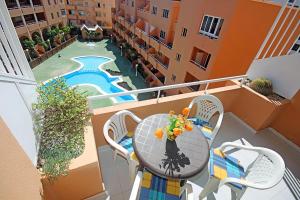 balkon ze stołem i krzesłami oraz basen w obiekcie MARINEDA by RENTMEDANO newly renovated, ocean view, wifi, parking, pool w mieście El Médano
